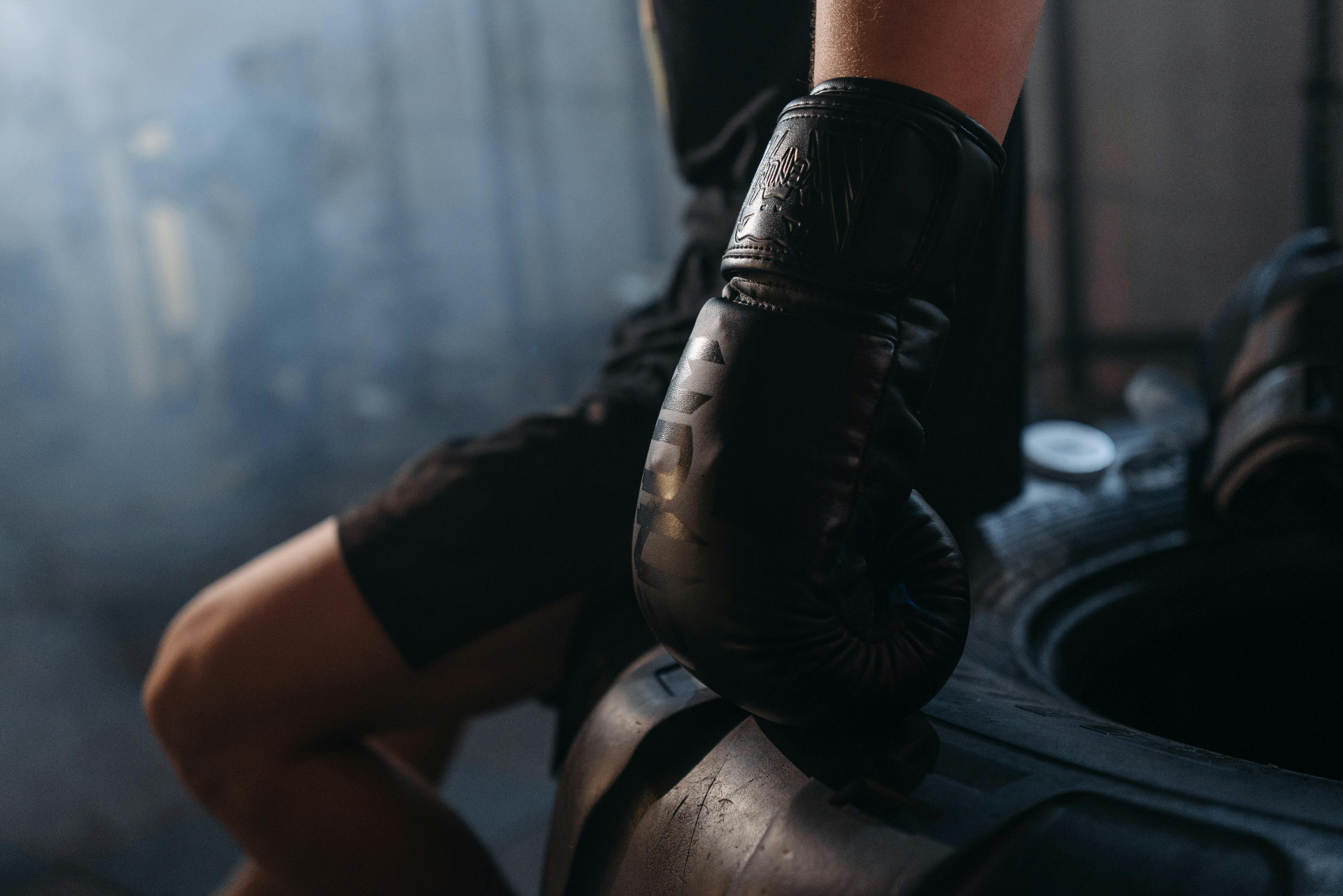 Boxer resting on tire with black gloves — Soviet Boxing Club Kolenchery